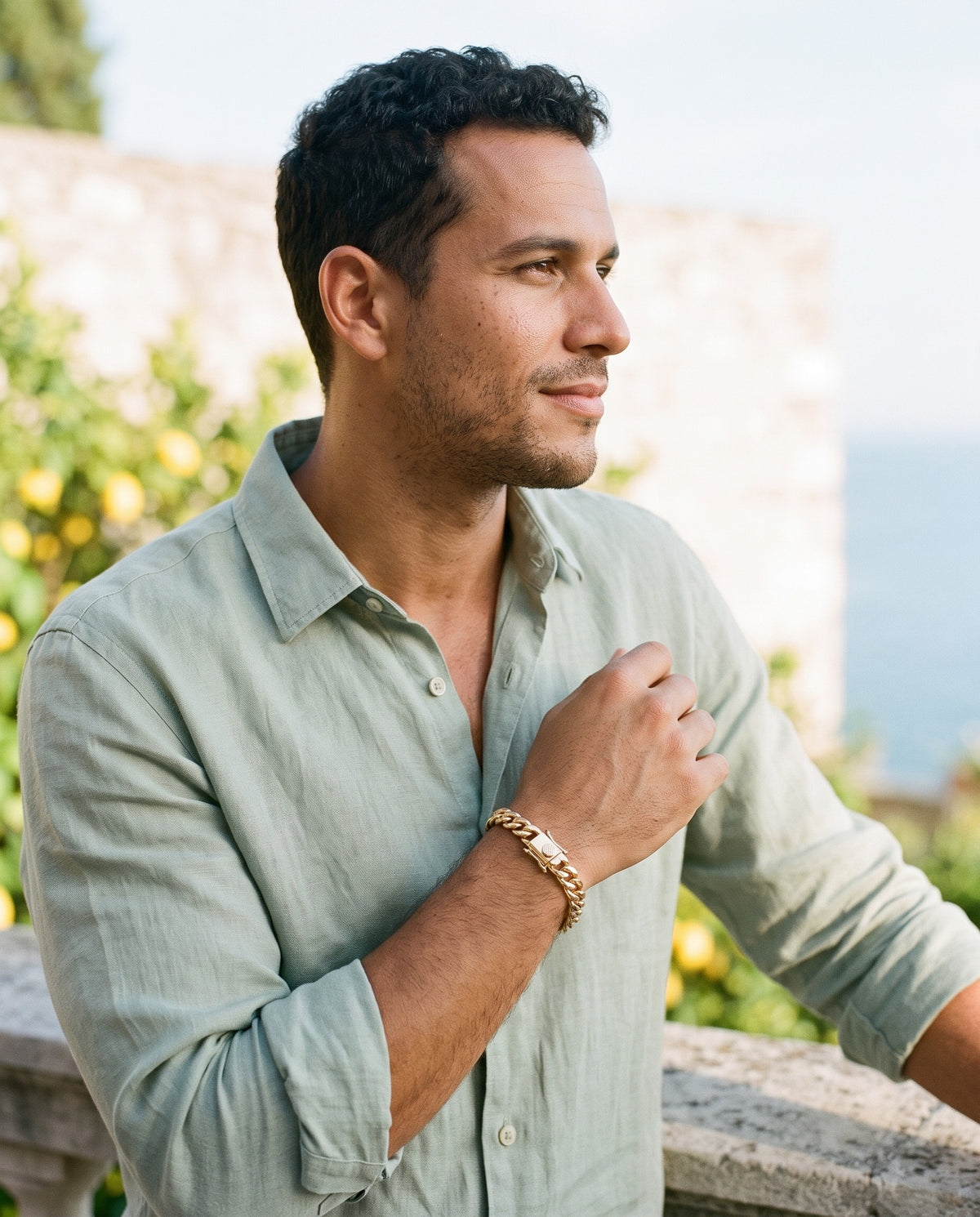 Man wearing the Marco Maveri Heavy Curb Chain Bracelet by the sea, Gold