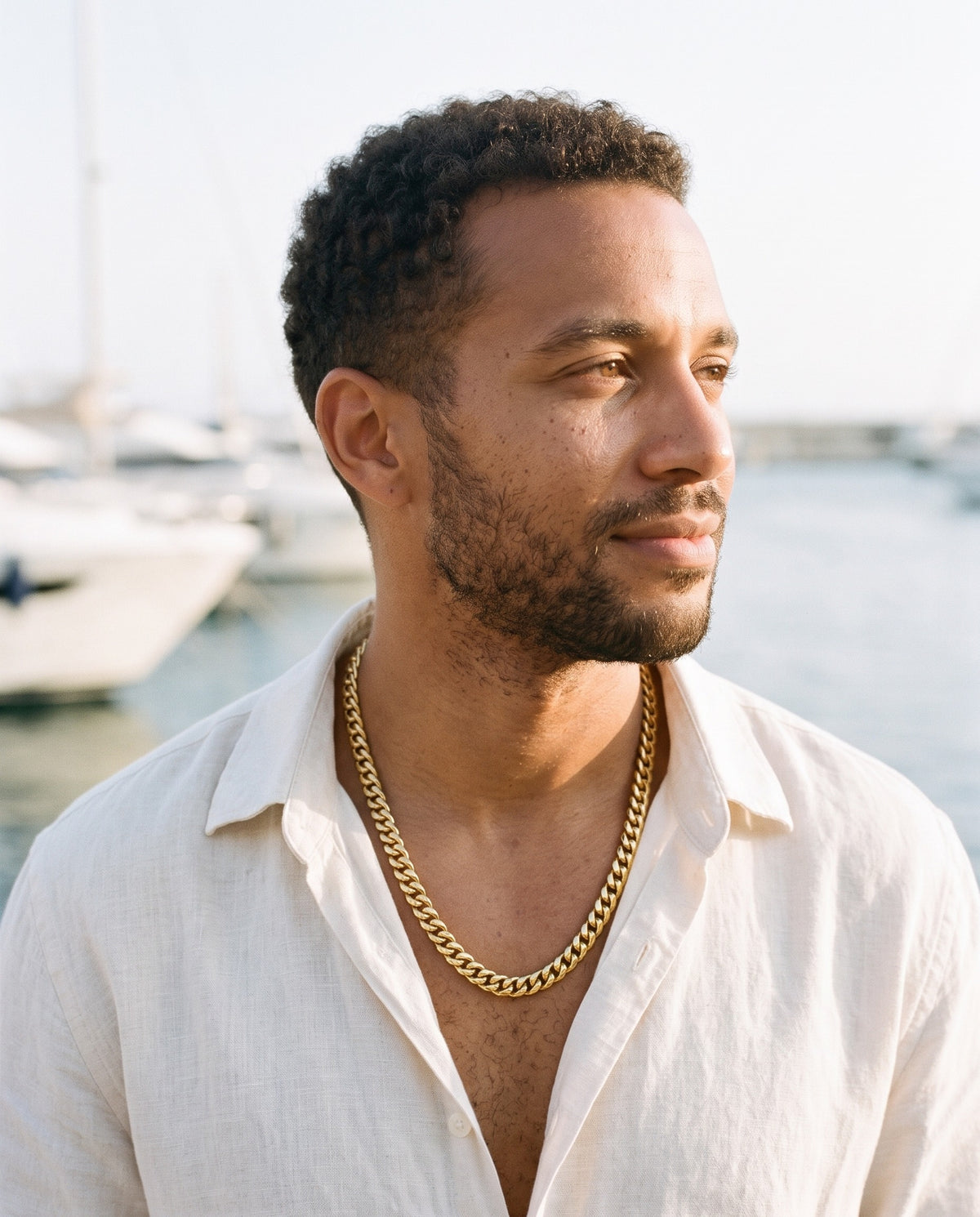 Man wearing the Marco Maveri Heavy Curb Chain Necklace by the sea, Gold