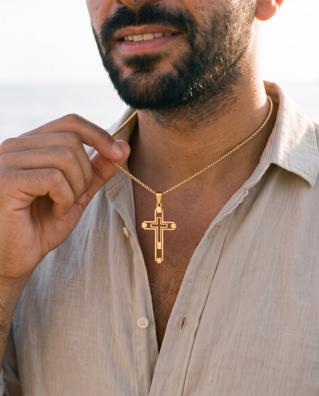 Man adjusting the Marco Maveri Hollow Double Cross Pendant Necklace, close-up, Gold
