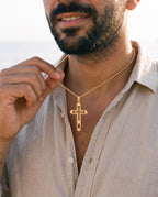 Man adjusting the Marco Maveri Hollow Double Cross Pendant Necklace, close-up, Gold