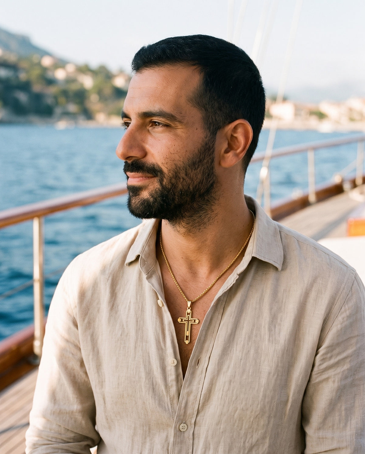 Man wearing the Marco Maveri Hollow Double Cross Pendant Necklace by the sea, Gold
