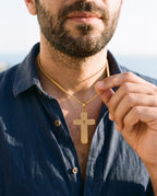 Man adjusting the Marco Maveri Lord's Prayer Cross Pendant Necklace, close-up, Gold