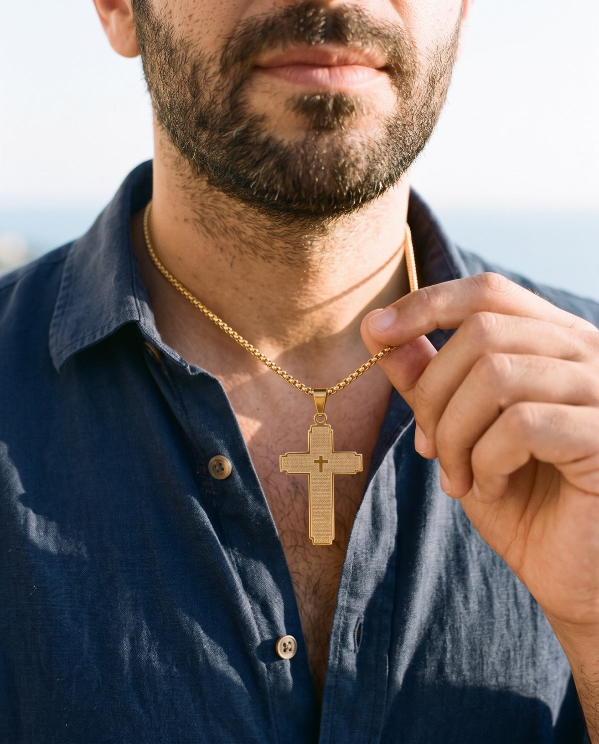 Man adjusting the Marco Maveri Lord's Prayer Cross Pendant Necklace, close-up, Gold
