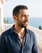 Man wearing the Marco Maveri Lord's Prayer Cross Pendant Necklace by the sea, Gold
