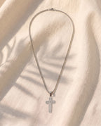 Marco Maveri Lord's Prayer Cross Pendant Necklace laid on cream linen, Silver
