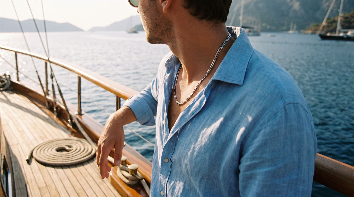 Figaro chain worn with a sky blue linen shirt on a wooden sailboat deck