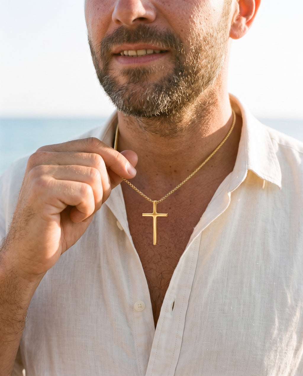 Man adjusting the Marco Maveri Minimalist Cross Pendant Necklace, close-up, Gold