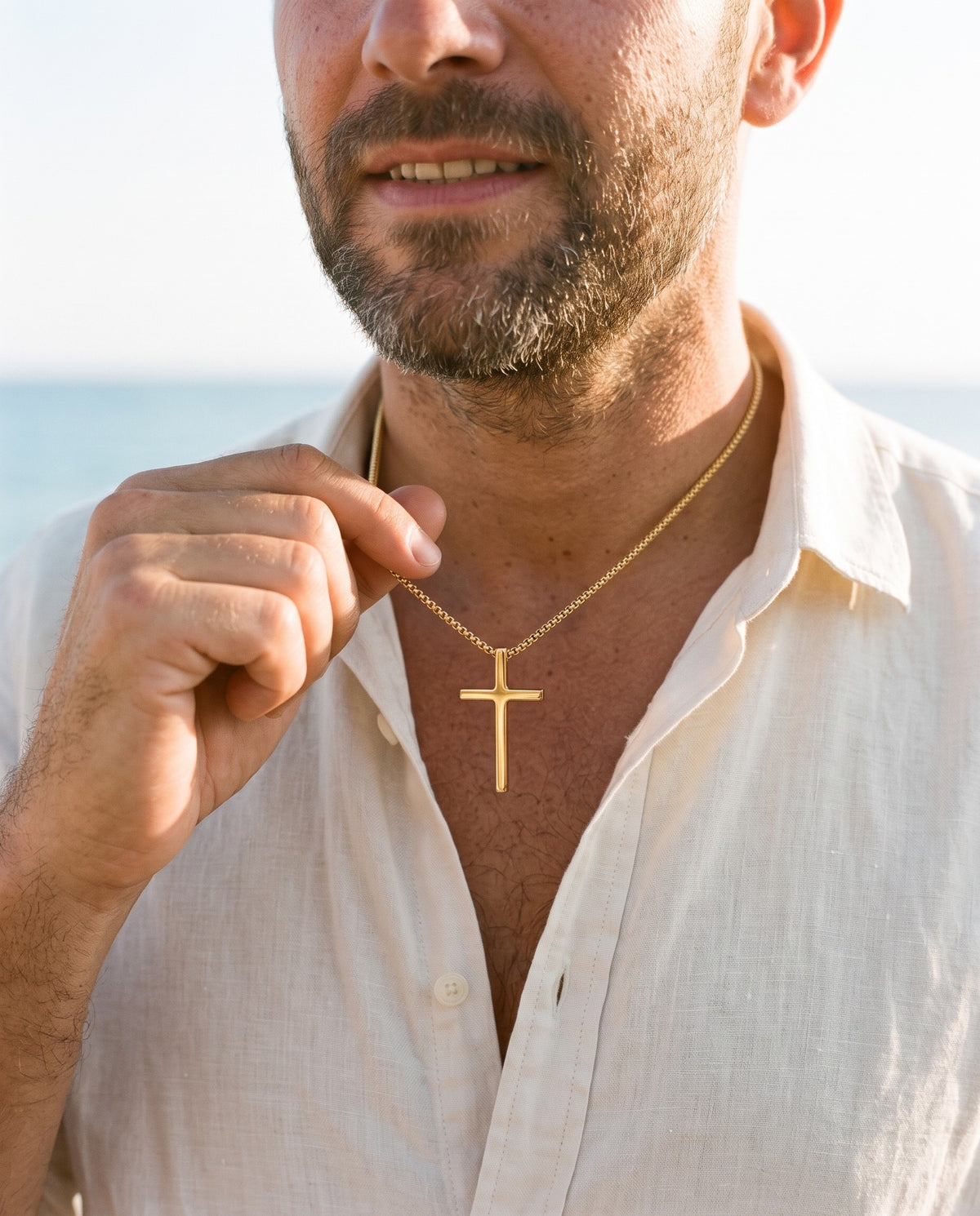 Man adjusting the Marco Maveri Minimalist Cross Pendant Necklace, close-up, Gold