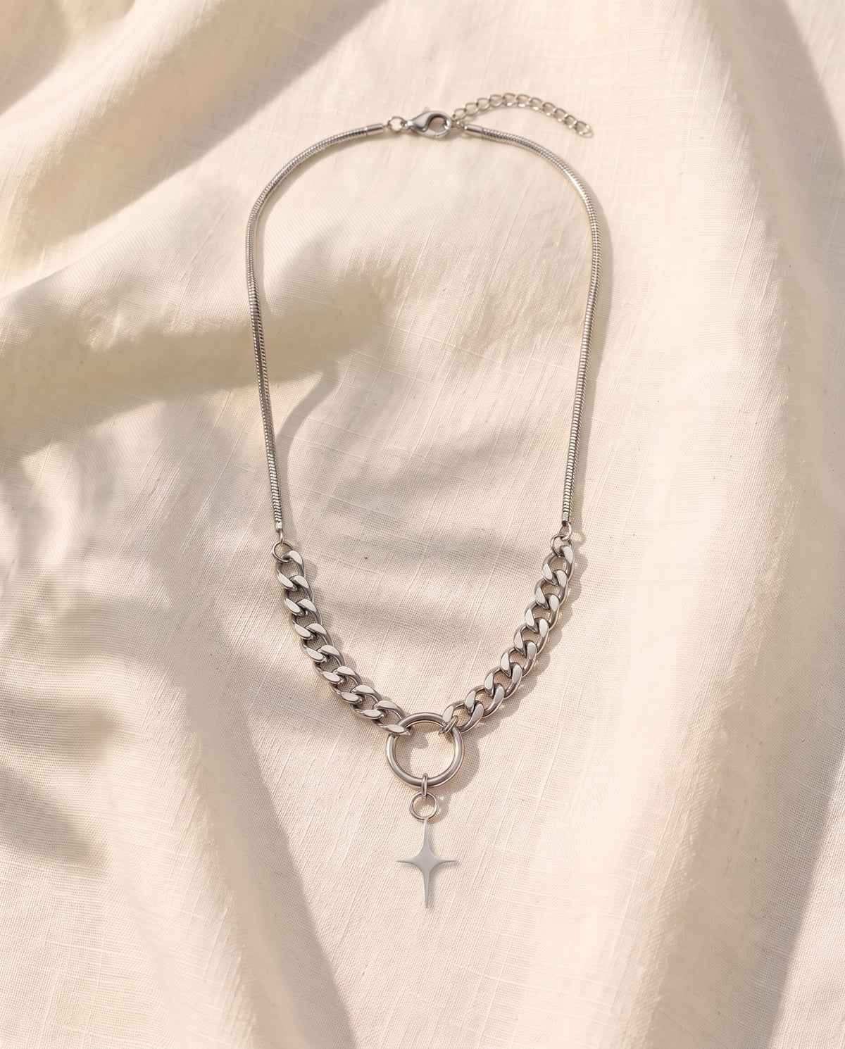 Marco Maveri Mixed Chain with Four-Point Star Pendant laid on cream linen, Silver