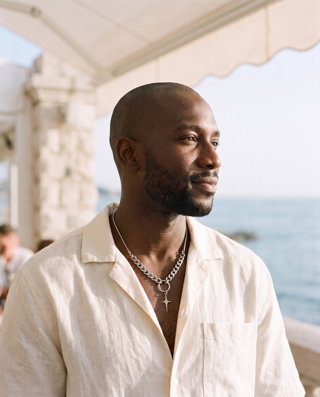 Man wearing the Marco Maveri Mixed Chain with Four-Point Star Pendant by the sea, Silver