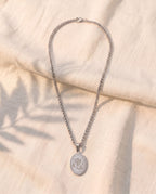 Marco Maveri Oval Medallion Pendant Necklace laid on cream linen, Silver