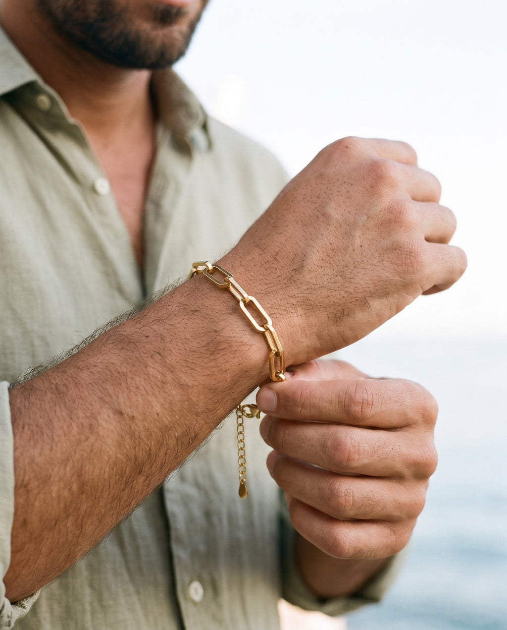 Man adjusting the Marco Maveri Paperclip Link Bracelet, close-up, Gold