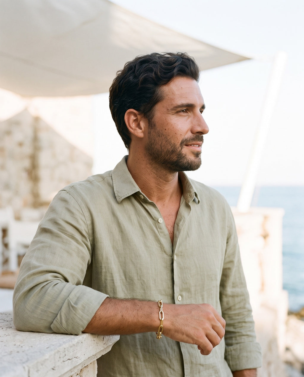 Man wearing the Marco Maveri Paperclip Link Bracelet by the sea, Gold