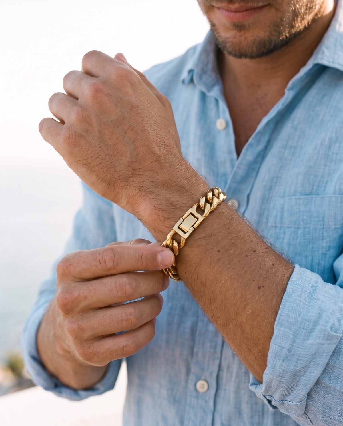 Man adjusting the Marco Maveri Polished Cuban Link Bracelet, close-up, Gold