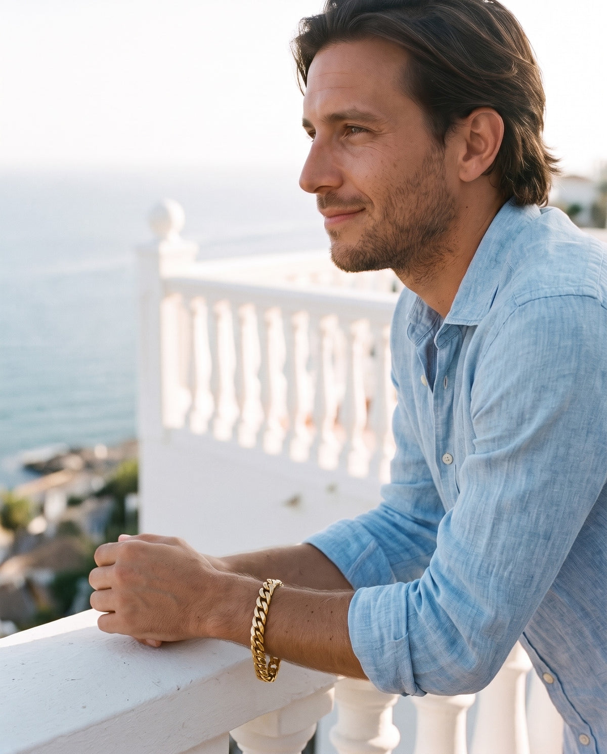Man wearing the Marco Maveri Polished Cuban Link Bracelet by the sea, Gold