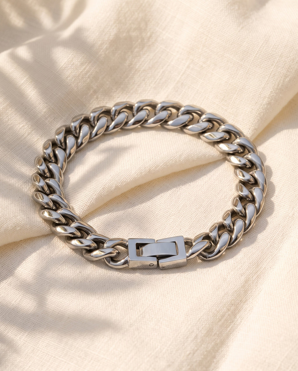 Marco Maveri Polished Cuban Link Bracelet laid on cream linen, Silver