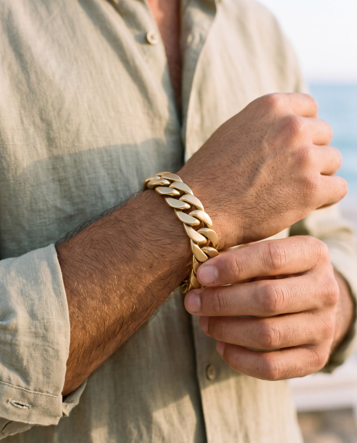 Man adjusting the Marco Maveri Polished Curb Link Bracelet, close-up, Gold