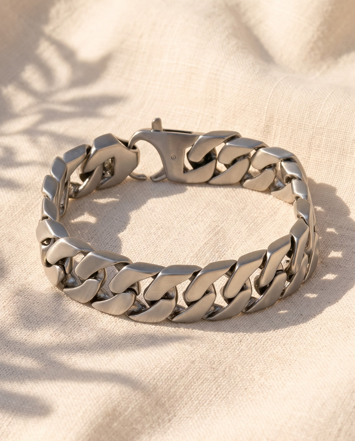 Marco Maveri Polished Curb Link Bracelet laid on cream linen, Silver