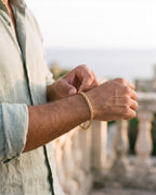 Man adjusting the Marco Maveri Rope Chain Bracelet in Stainless Steel, close-up, Gold