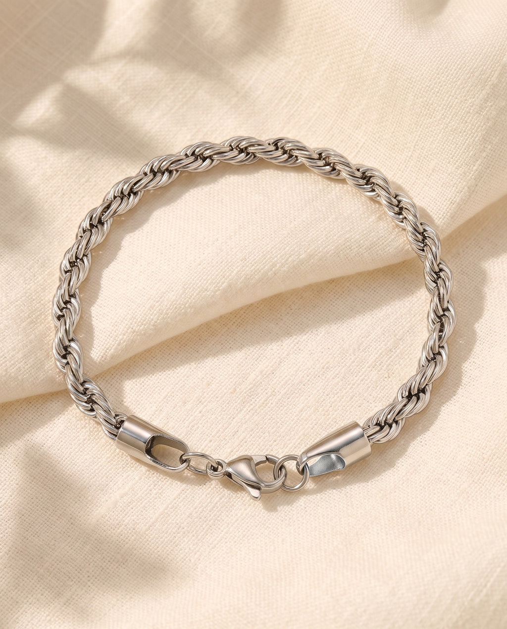 Marco Maveri Rope Chain Bracelet in Stainless Steel laid on cream linen, Silver