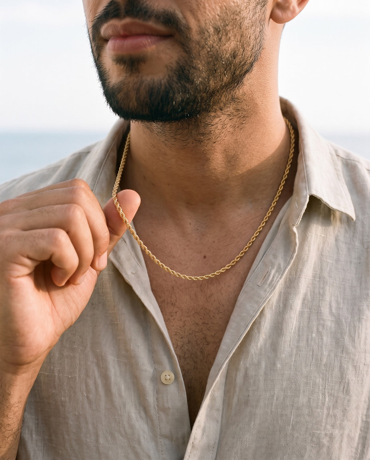 Man adjusting the Marco Maveri Rope Chain in Gold-Tone Titanium Steel, close-up, Gold