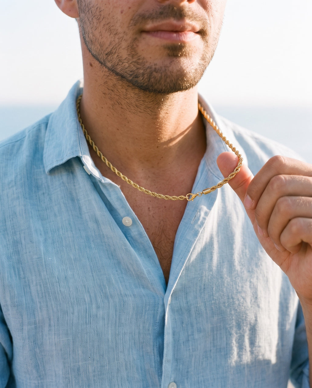 Man adjusting the Marco Maveri Rope Chain Necklace in Stainless Steel, close-up, Gold