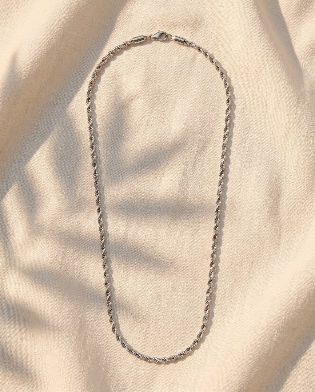 Marco Maveri Rope Chain Necklace in Stainless Steel laid on cream linen, Silver