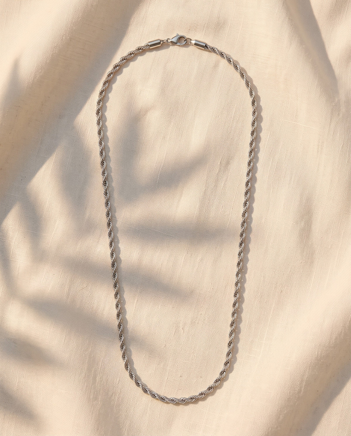 Marco Maveri Rope Chain Necklace in Stainless Steel laid on cream linen, Silver