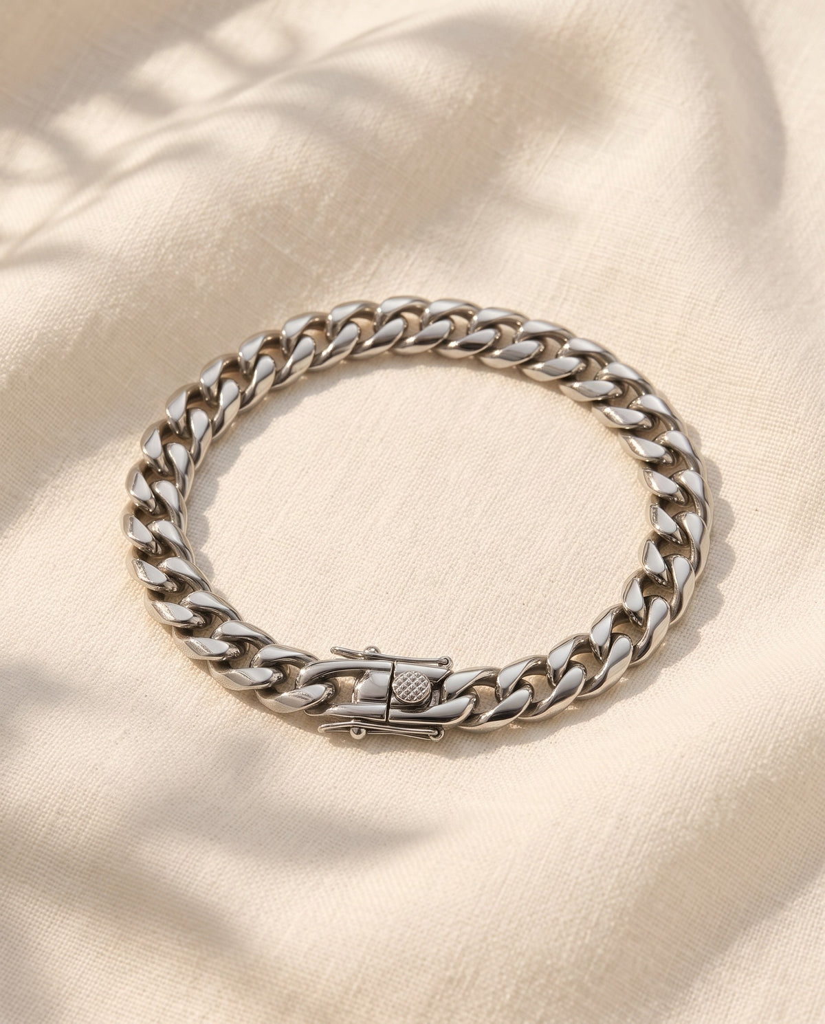 Marco Maveri Silver Cuban Link Bracelet laid on cream linen, Silver
