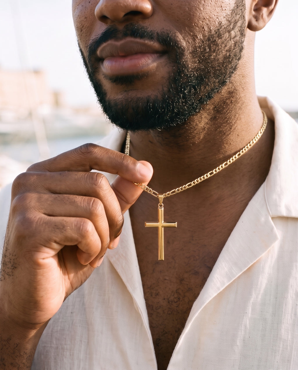 Man adjusting the Marco Maveri Slim Cross Pendant Necklace, close-up, Gold
