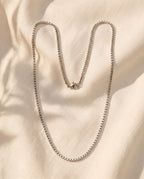 Marco Maveri Stainless Steel Box Chain Necklace laid on cream linen, Silver