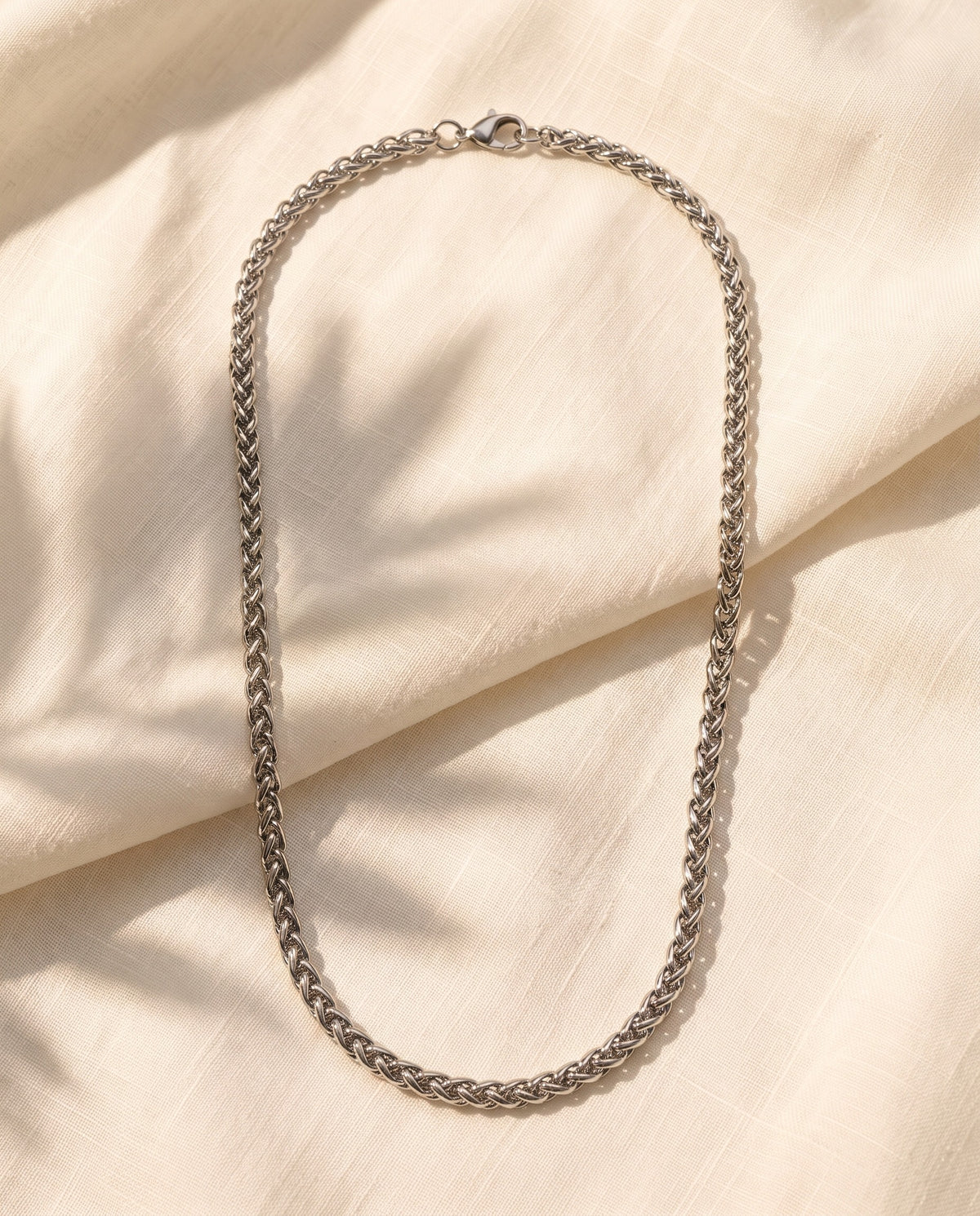 Marco Maveri Titanium Steel Wheat Chain laid on cream linen, Silver
