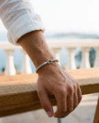 Marco Maveri Twisted Steel Hook Bangle worn with a linen shirt, close-up, Silver