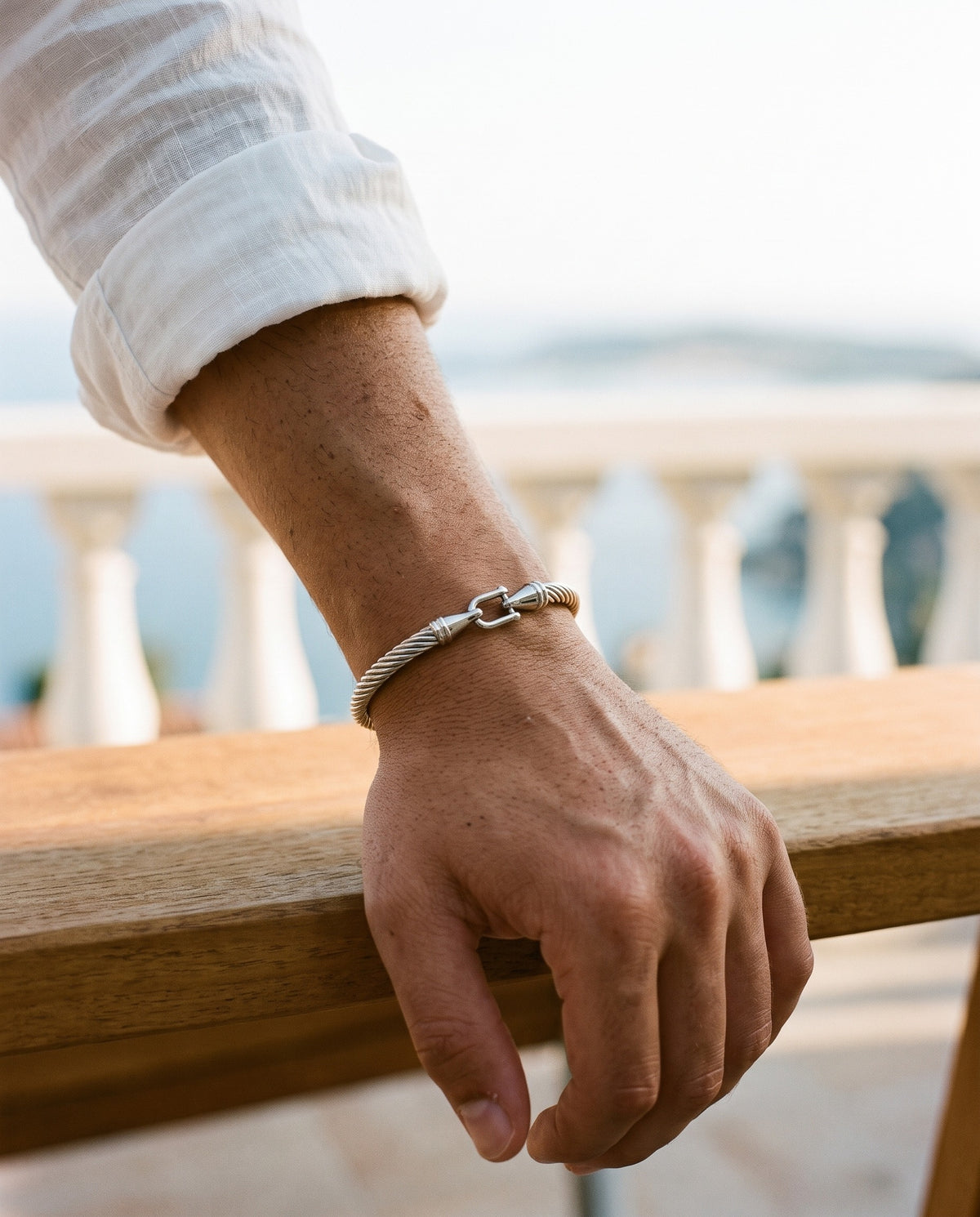 Marco Maveri Twisted Steel Hook Bangle worn with a linen shirt, close-up, Silver