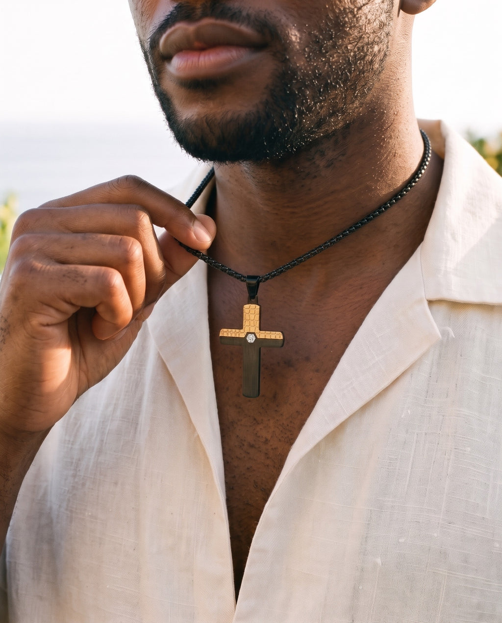 Man adjusting the Marco Maveri Two-Tone Inlaid Cross Pendant Necklace, close-up, Black / Gold