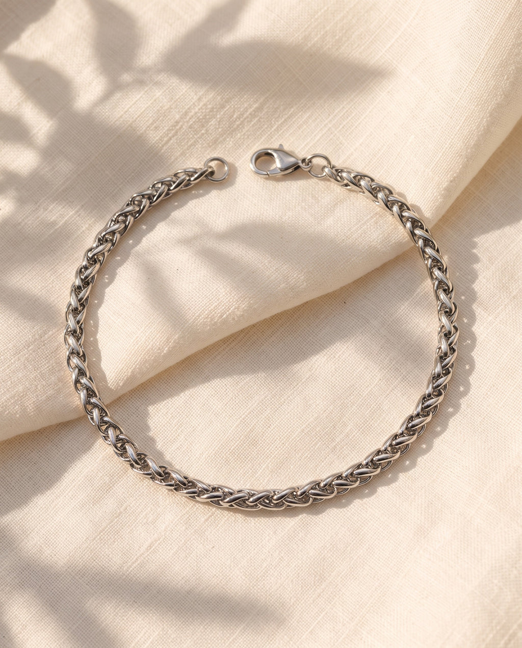 Marco Maveri Wheat Link Chain Bracelet laid on cream linen, Silver