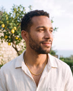 Man wearing the Marco Maveri Wheat Link Chain in Titanium Steel by the sea, Gold